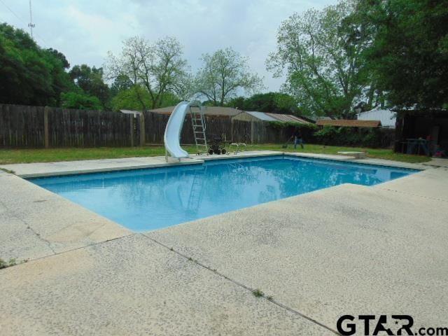 view of pool featuring a patio area, a fenced backyard, a water slide, and a fenced in pool