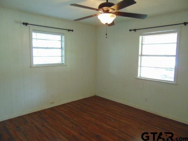 unfurnished room featuring ceiling fan, baseboards, wood finished floors, and plenty of natural light
