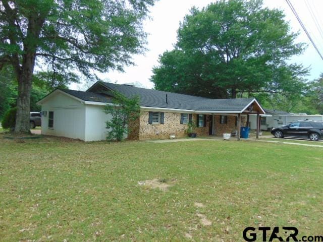 ranch-style house featuring a front yard and covered porch