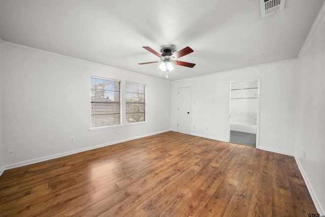 unfurnished bedroom featuring ornamental molding, dark hardwood / wood-style floors, ceiling fan, and ensuite bath