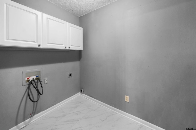 clothes washing area featuring hookup for a washing machine, cabinets, a textured ceiling, and hookup for an electric dryer