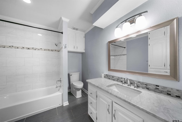 full bathroom featuring tile patterned flooring, tiled shower / bath combo, vanity, ornamental molding, and toilet