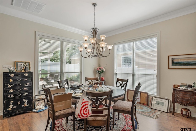 3953 Hanover Pl, Tyler, TX 75701 - dining room featuring a chandelier, wood finished floors, crown molding, and healthy amount of natural light