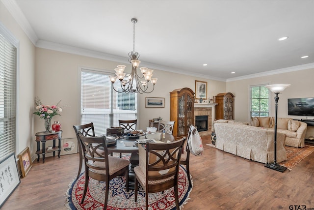3953 Hanover Pl, Tyler, TX 75701 - dining room featuring wood finished floors, a chandelier, recessed lighting, a fireplace with raised hearth, and ornamental molding
