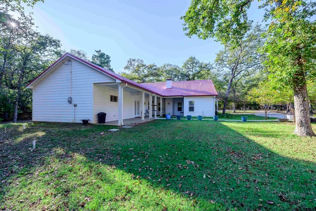 back of house featuring ceiling fan and a lawn