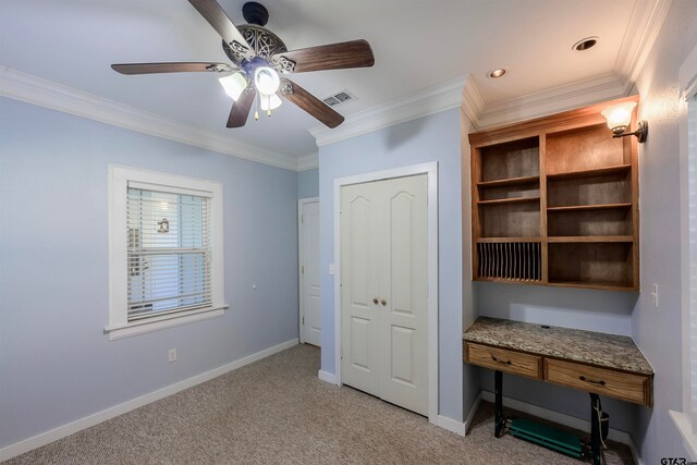 unfurnished office with ceiling fan, light carpet, and ornamental molding