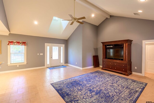 unfurnished living room with high vaulted ceiling, ceiling fan, a skylight, and beam ceiling