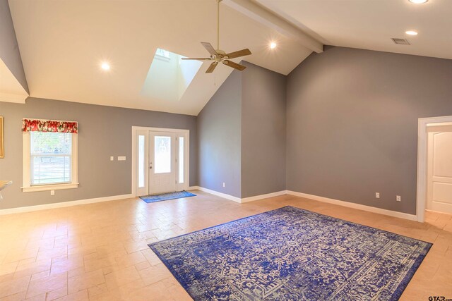 entrance foyer featuring high vaulted ceiling, a skylight, ceiling fan, and beam ceiling