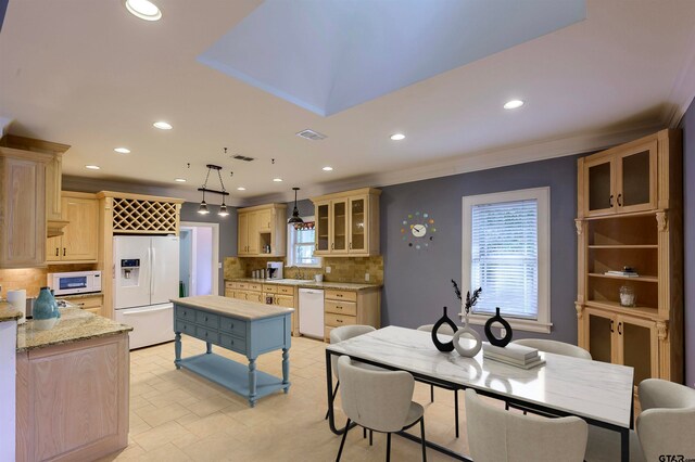 kitchen with decorative backsplash, hanging light fixtures, light stone countertops, light brown cabinetry, and white appliances