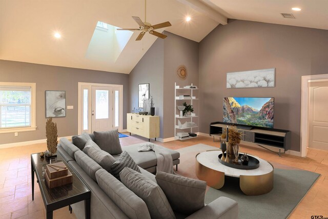 living room with high vaulted ceiling, beamed ceiling, a skylight, and ceiling fan