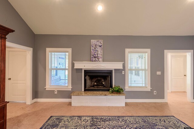 unfurnished living room featuring lofted ceiling and a healthy amount of sunlight