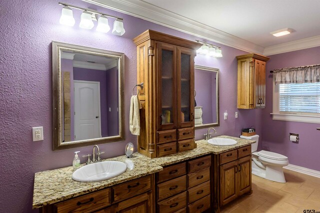 bathroom with toilet, vanity, and crown molding