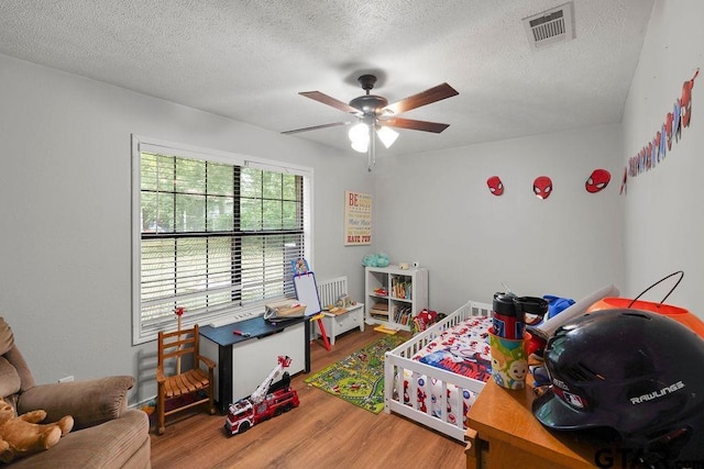 260 County Road 2302, Rusk, TX 75785 - bedroom with wood finished floors, a textured ceiling, and ceiling fan