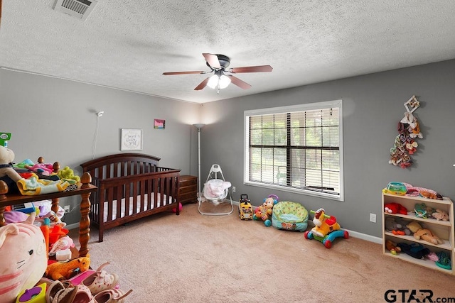 260 County Road 2302, Rusk, TX 75785 - carpeted bedroom featuring baseboards, a textured ceiling, a ceiling fan, and a crib