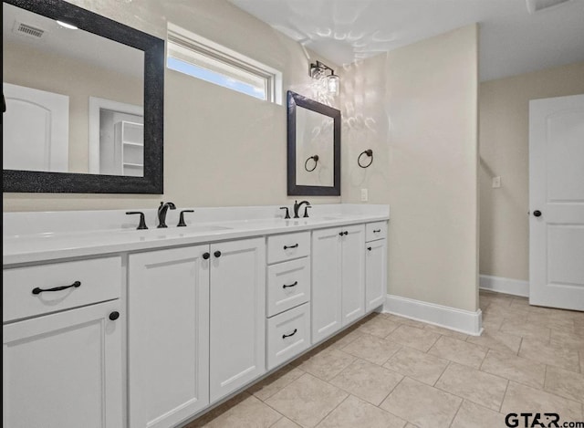 full bathroom with baseboards, double vanity, tile patterned floors, visible vents, and a sink