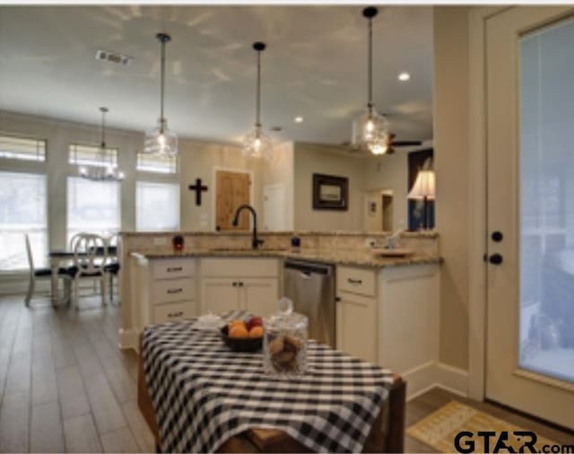 kitchen with white cabinets, dishwasher, a sink, and dark wood finished floors