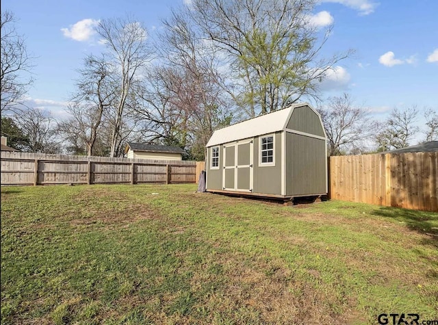 view of yard featuring an outbuilding, a fenced backyard, and a storage unit