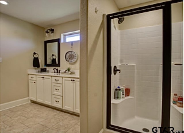 bathroom with tile patterned flooring, baseboards, a stall shower, and vanity