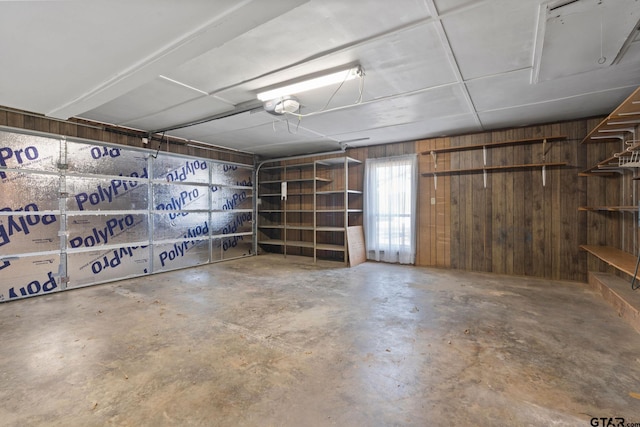 garage with a garage door opener and wooden walls