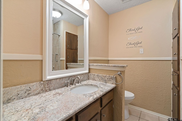 bathroom featuring walk in shower, tile patterned floors, a textured ceiling, toilet, and vanity