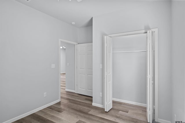 unfurnished bedroom with light wood-type flooring and a closet