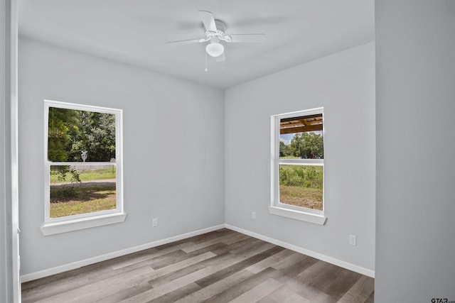 spare room featuring ceiling fan, light hardwood / wood-style flooring, and a wealth of natural light