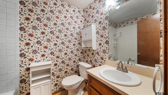 bathroom featuring vanity, toilet, a textured ceiling, and tiled shower