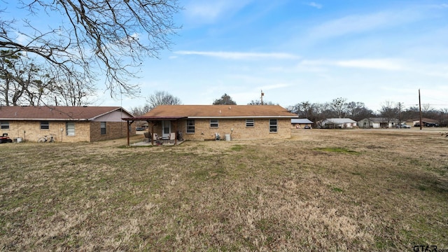 rear view of house featuring a yard and a patio area