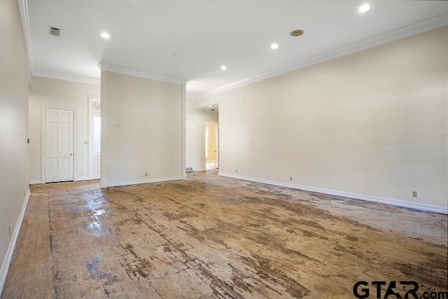 spare room featuring visible vents, baseboards, crown molding, and wood finished floors