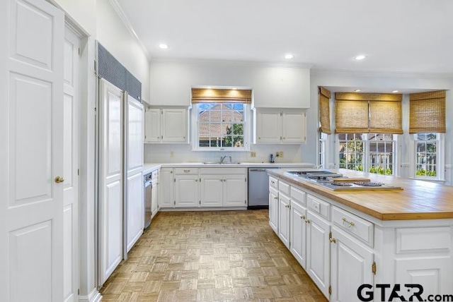 kitchen featuring recessed lighting, appliances with stainless steel finishes, white cabinetry, and butcher block countertops