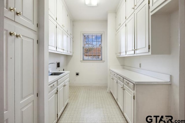 clothes washing area featuring washer hookup, a sink, baseboards, cabinet space, and electric dryer hookup