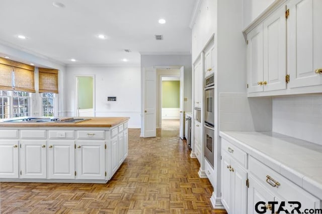 kitchen with recessed lighting, white cabinetry, stainless steel gas stovetop, and visible vents