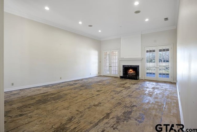 unfurnished living room featuring a fireplace, wood finished floors, baseboards, ornamental molding, and french doors