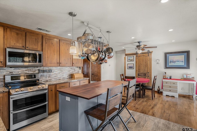 110 Vz County Road 2121, Canton, TX 75103 - kitchen featuring decorative light fixtures, tasteful backsplash, visible vents, appliances with stainless steel finishes, and light wood-style floors