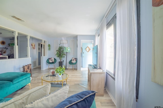 living area featuring plenty of natural light, light wood-style flooring, and visible vents