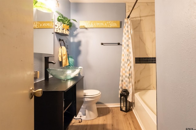 bathroom featuring shower / bath combo, toilet, baseboards, wood finished floors, and vanity