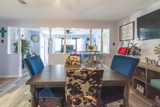 dining room featuring wood finished floors, visible vents, and a ceiling fan