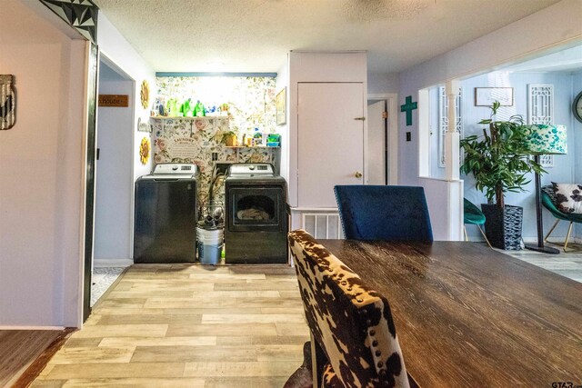 interior space featuring washing machine and dryer, light wood-style flooring, and a textured ceiling