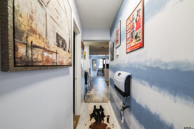 hallway featuring wood finished floors and heating unit