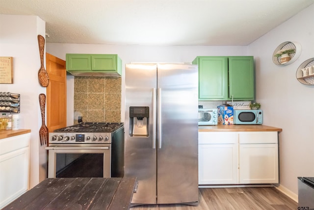 kitchen featuring green cabinetry, decorative backsplash, light wood finished floors, and appliances with stainless steel finishes