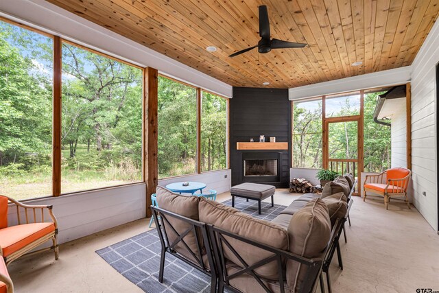 sunroom with an outdoor living space with a fireplace and ceiling fan