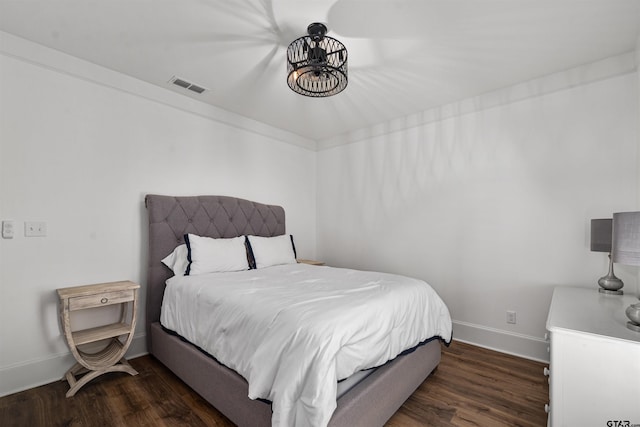 bedroom with visible vents, wood finished floors, and baseboards