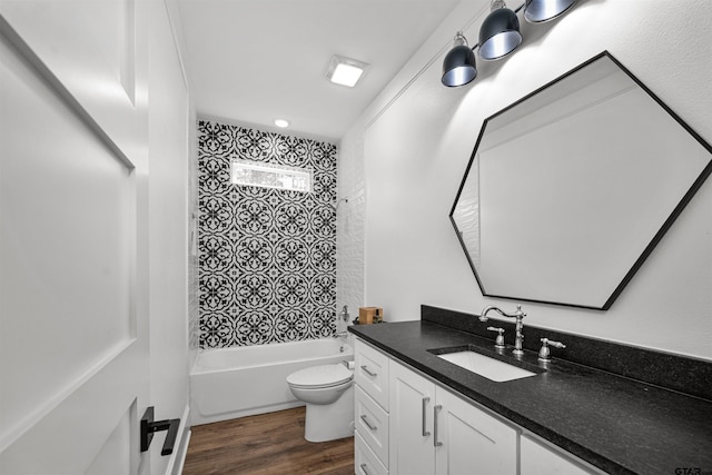 bathroom featuring toilet, vanity, bathing tub / shower combination, and wood finished floors