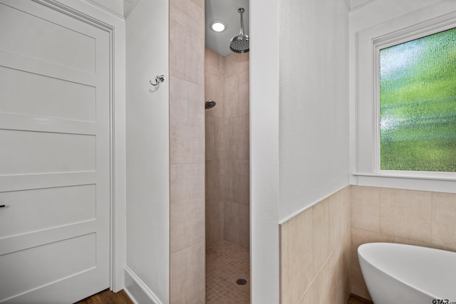 full bathroom featuring a tile shower and a freestanding tub