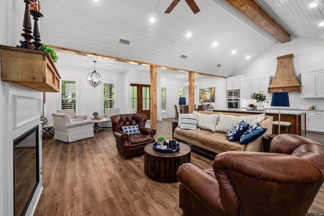 living room with beamed ceiling, visible vents, and wood finished floors