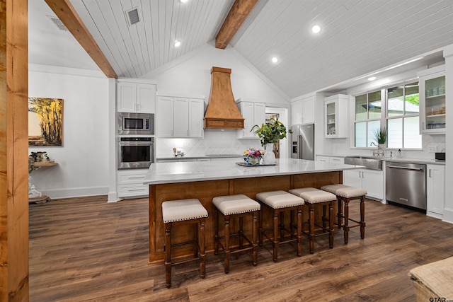 kitchen with recessed lighting, decorative backsplash, appliances with stainless steel finishes, a sink, and premium range hood