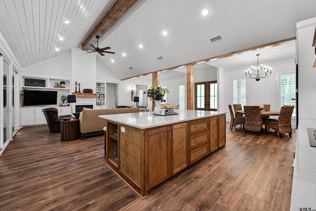 kitchen featuring a fireplace, brown cabinets, a kitchen island, and dark wood finished floors