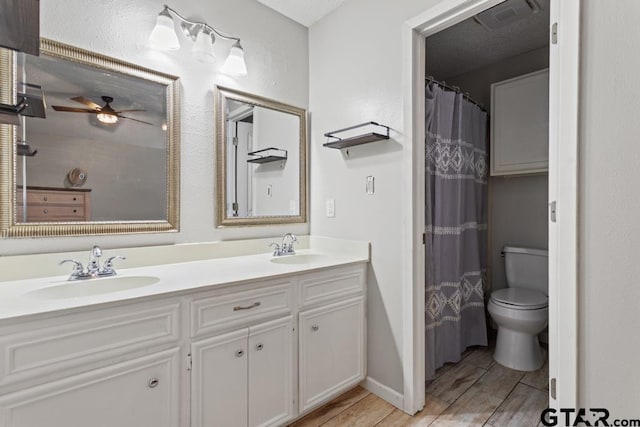 bathroom featuring vanity, curtained shower, ceiling fan, and toilet