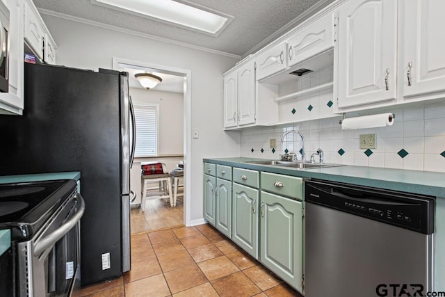 kitchen with sink, light tile patterned floors, appliances with stainless steel finishes, white cabinets, and decorative backsplash