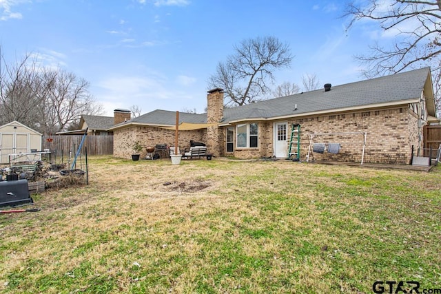 rear view of house with a storage unit and a lawn